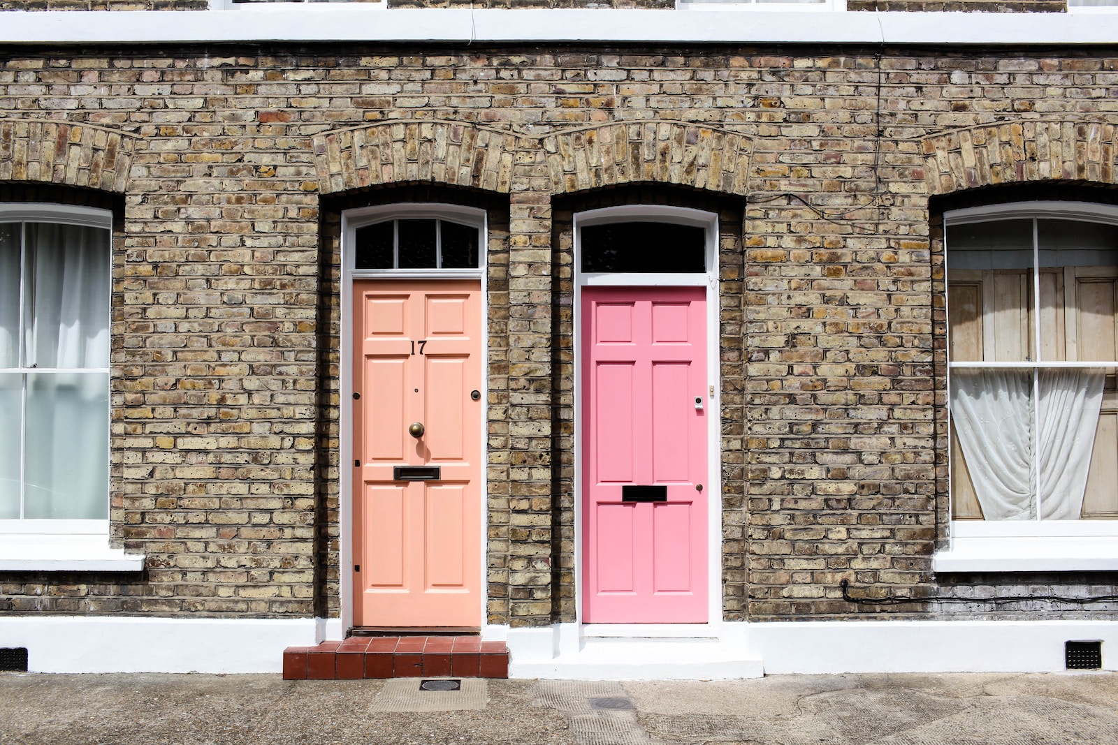 facciata inglese con deu porte colorate, una salmone e l'altra rosa